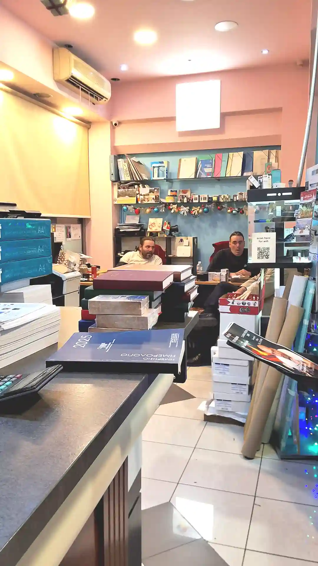 a group of men sitting at a desk in a room with books